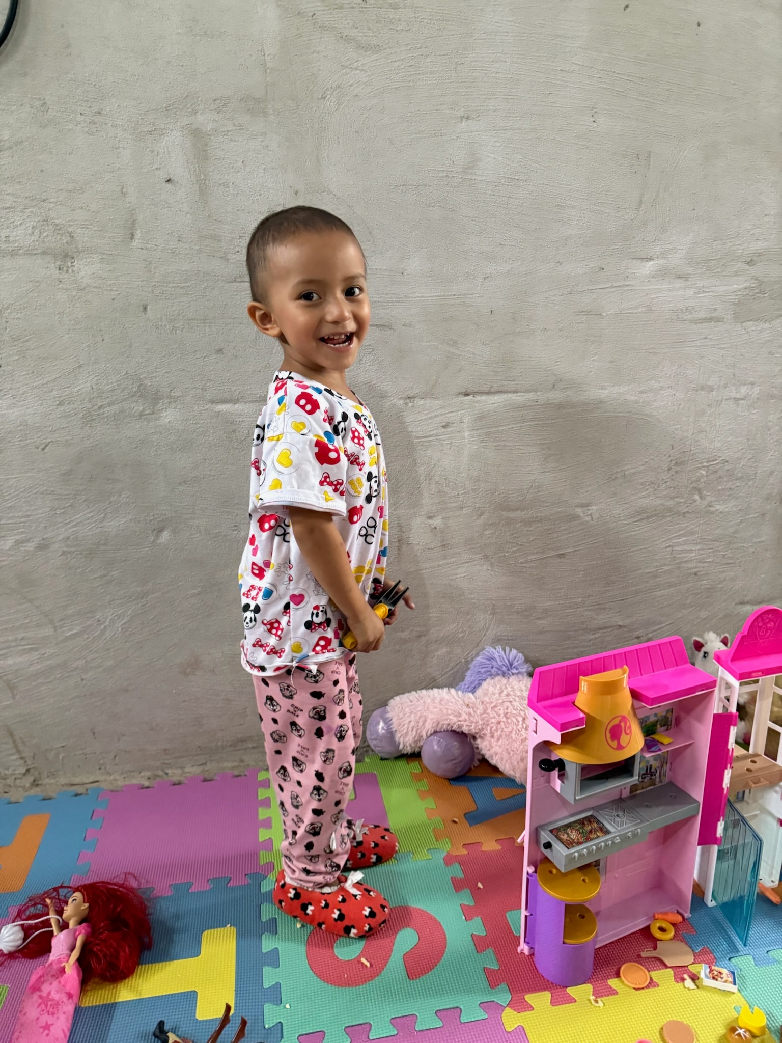 Toddler smiling in a playroom with toys