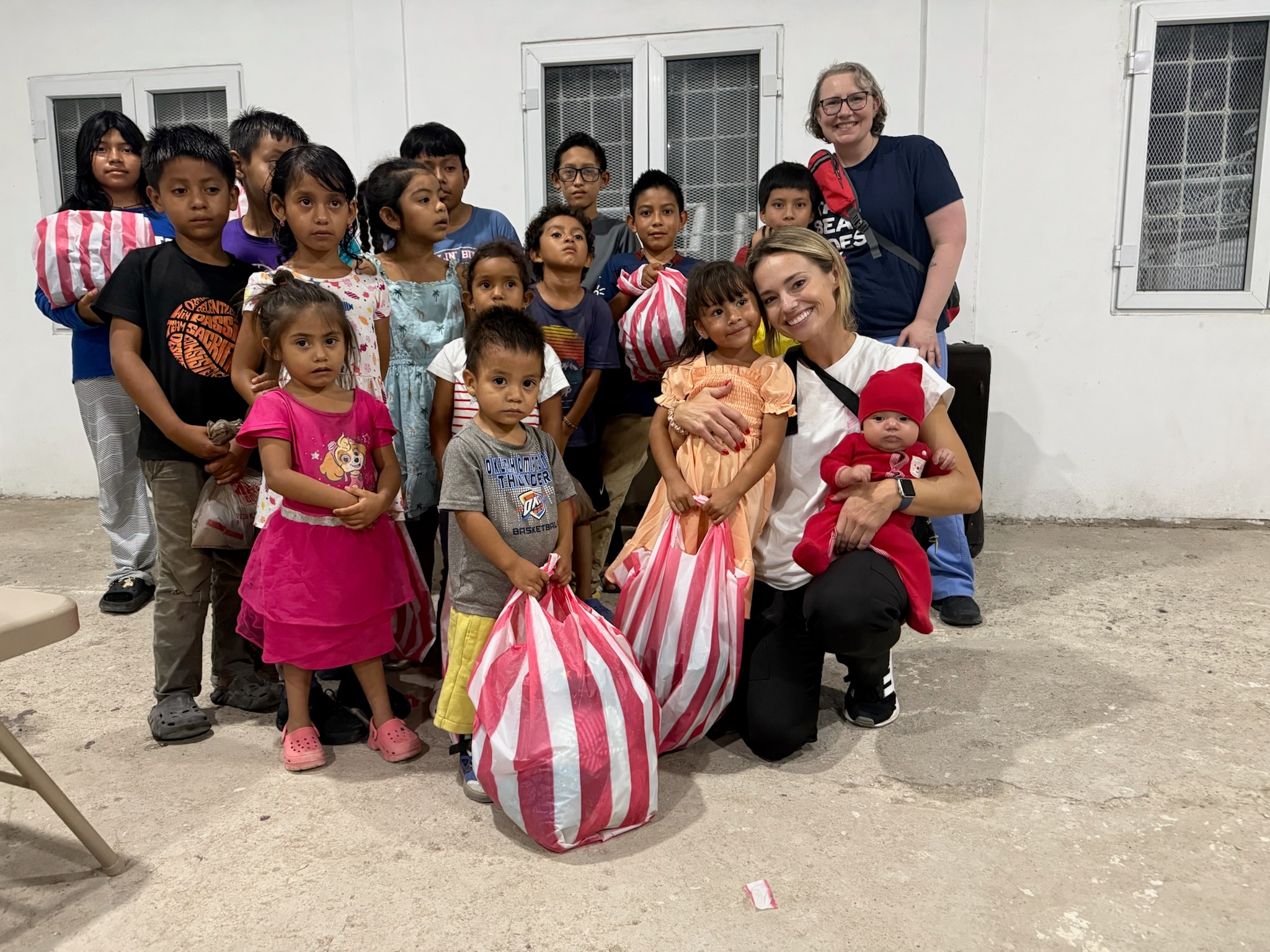 A volunteer with a group of children outdoors
