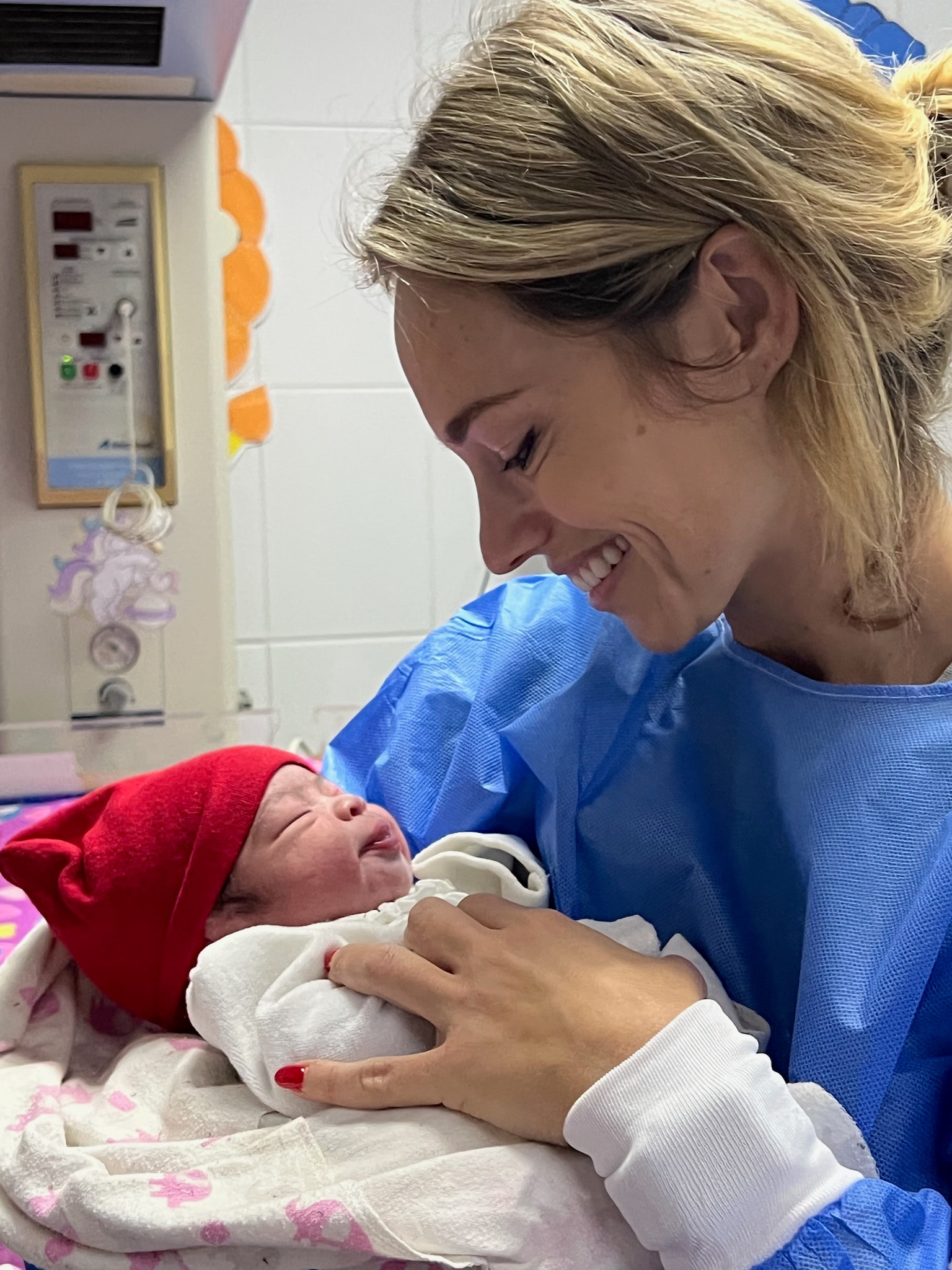 Healthcare worker holding a newborn baby at the hospital